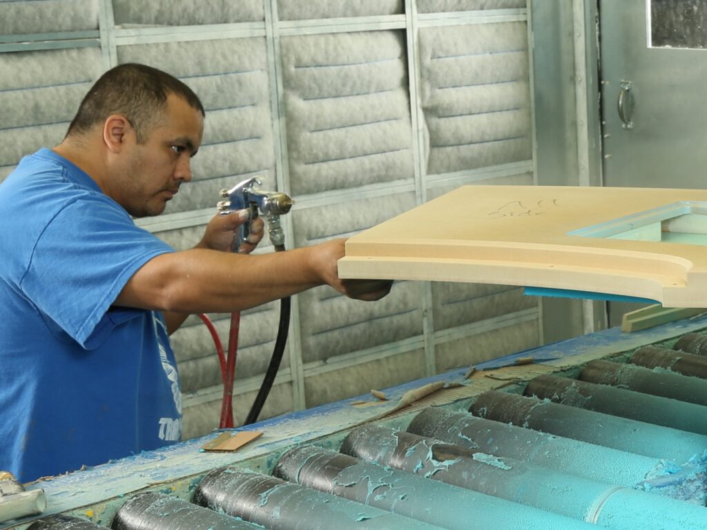 Technician operating a membrane press at Paladin Industries for precision panel forming.
