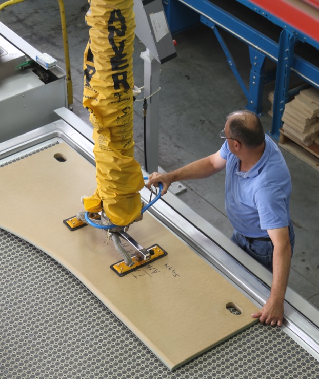Paladin worker using a membrane pressing machine for complex 3D surfaces.