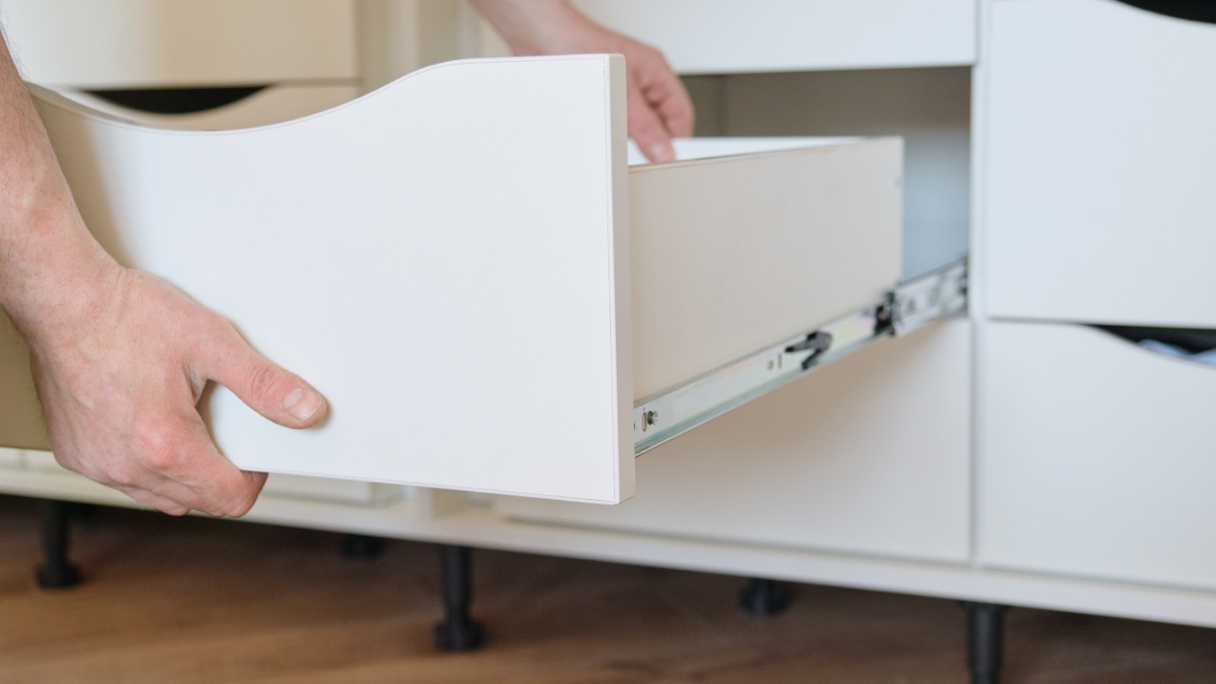 Laminate cabinet with drawer sliding out.