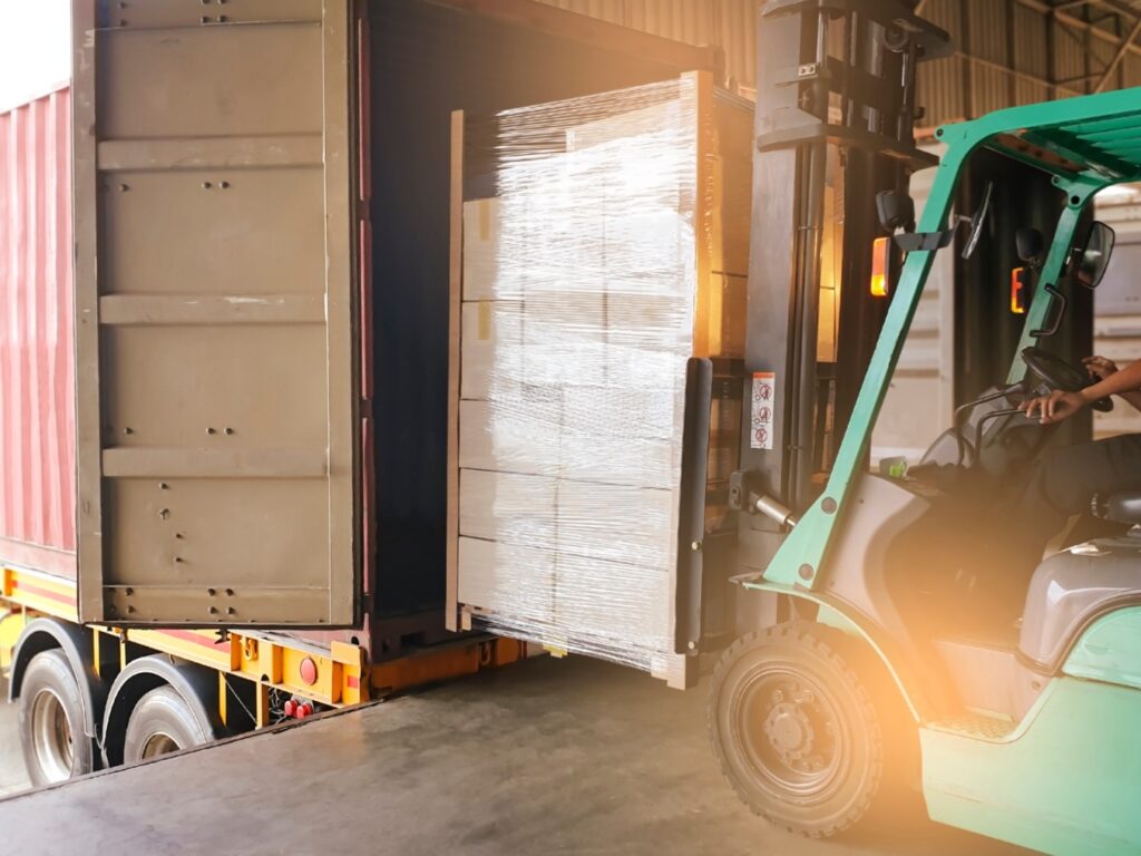 Hilo loading packaged products into back of semi-truck.