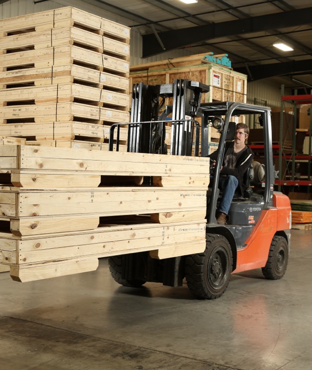 Man running hilo with products stacked, ready for shipping.