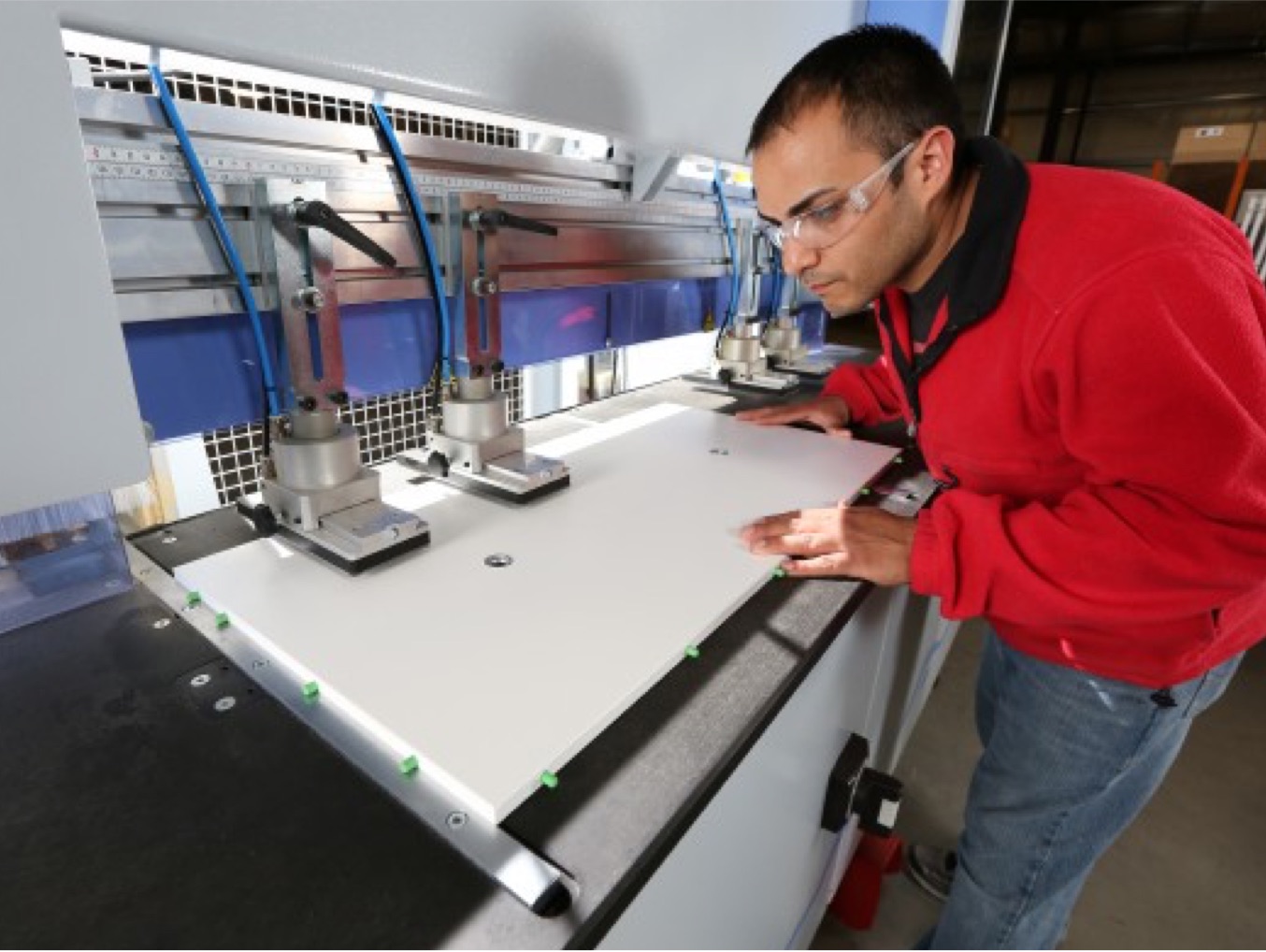 Man working on a machine doing bore/dowel insertion.