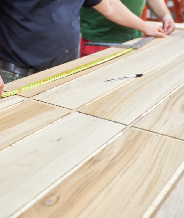 Closeup of person measuring a wood furniture piece